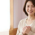 スミス・マゲニス症候群の入浴ガイドについて紹介するベージュのカーディガンを着て微笑む女性アドバイザーの横長写真