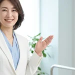 尿道カテーテルがある子どもの入浴ガイドを解説する白ジャケットとライトブルーインナー姿の女性アドバイザーの横長写真